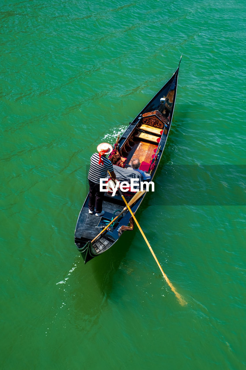 HIGH ANGLE VIEW OF MAN SAILING ON SEA