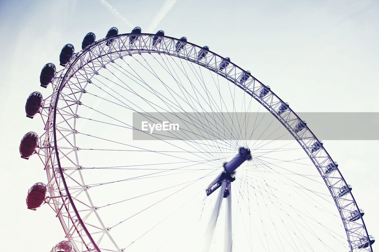 Low angle view of ferris wheel against clear blue sky