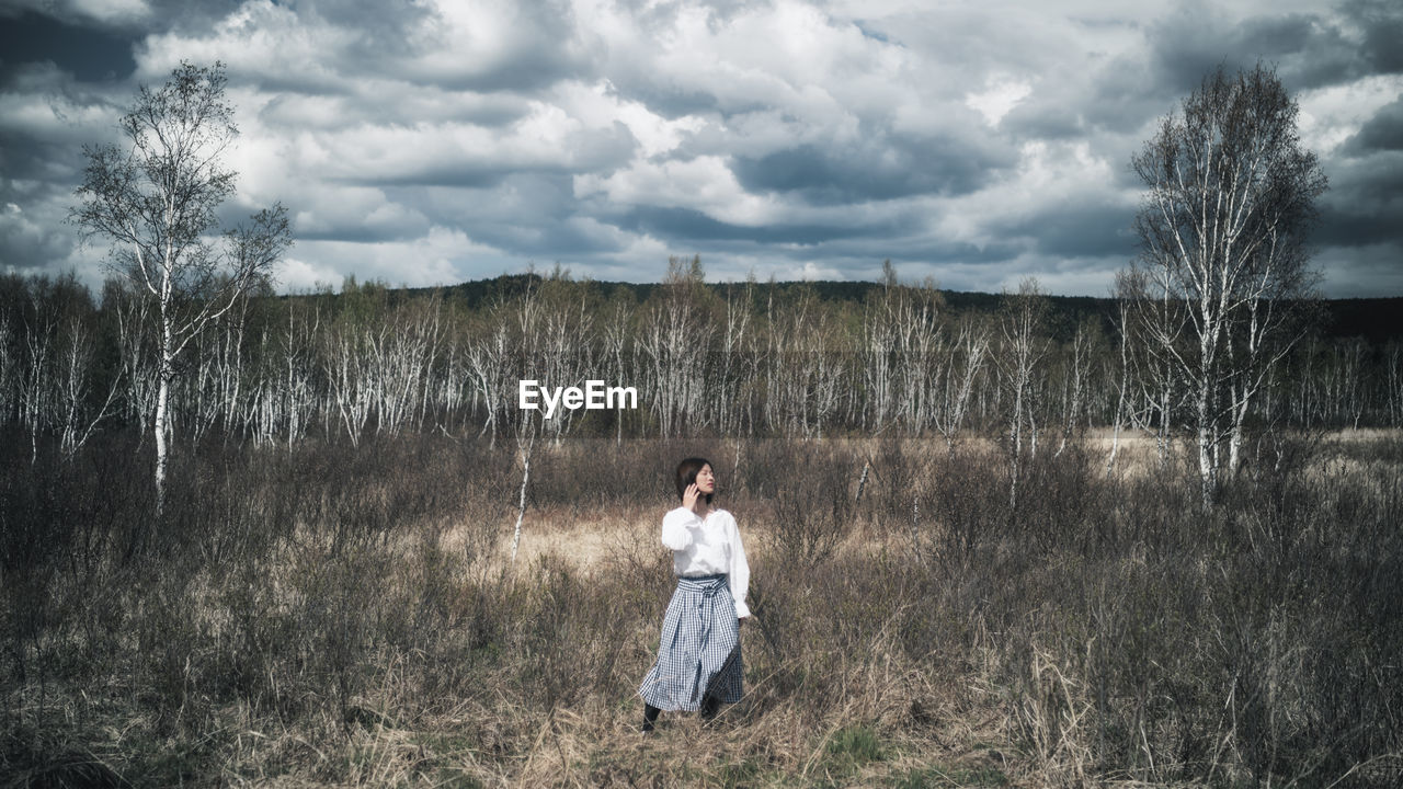 FULL LENGTH OF WOMAN STANDING ON FIELD