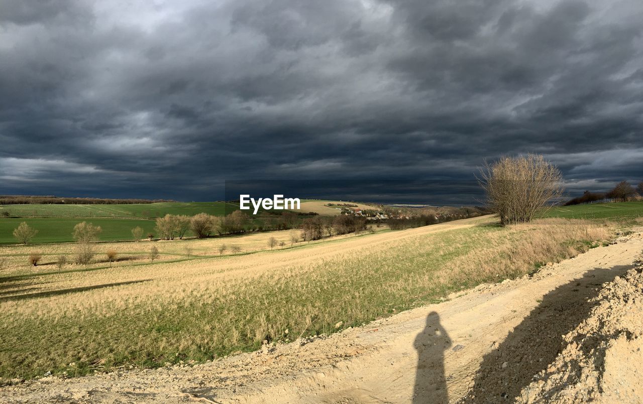 STORM CLOUDS OVER AGRICULTURAL FIELD
