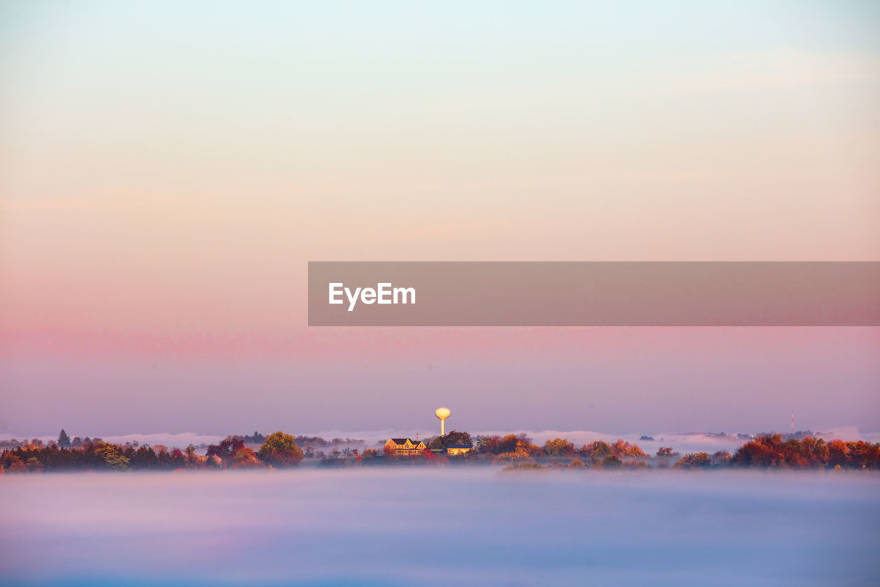 Hilltop neighborhood surrounded by clouds at sunrise