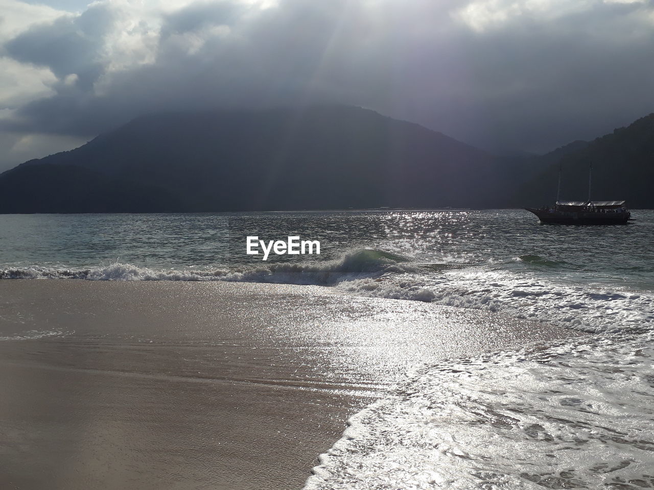 SCENIC VIEW OF SEA BY MOUNTAINS AGAINST SKY