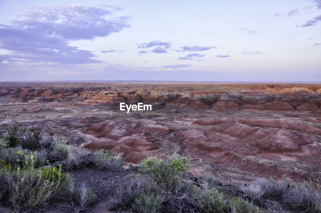 Rock formations on landscape against cloudy sky