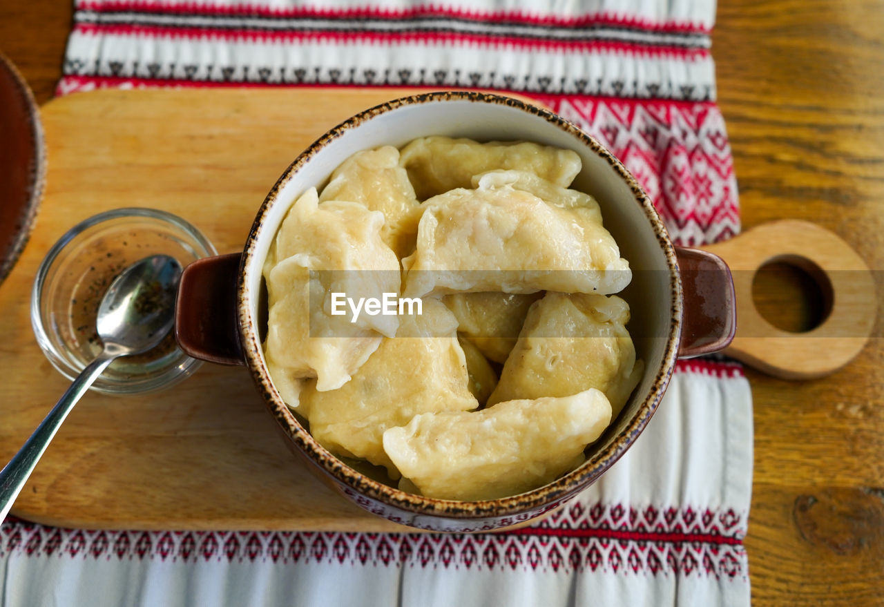 Dumplings with fish in a pot on a wooden table. ukrainian cuisine