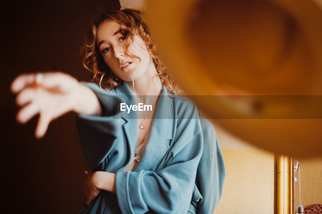 Portrait of young woman standing at home