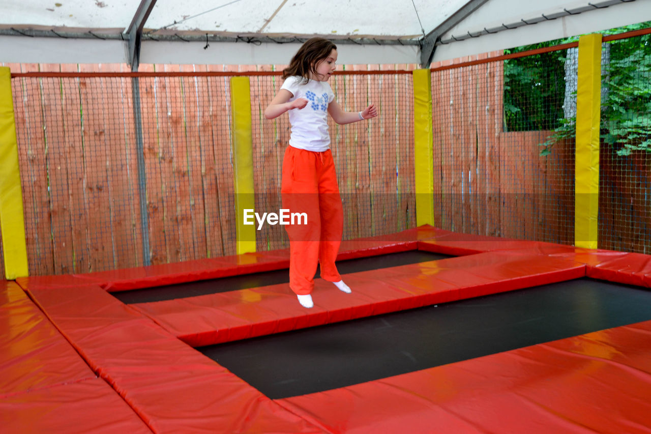 Happy sports girl having fun while jumping on trampoline