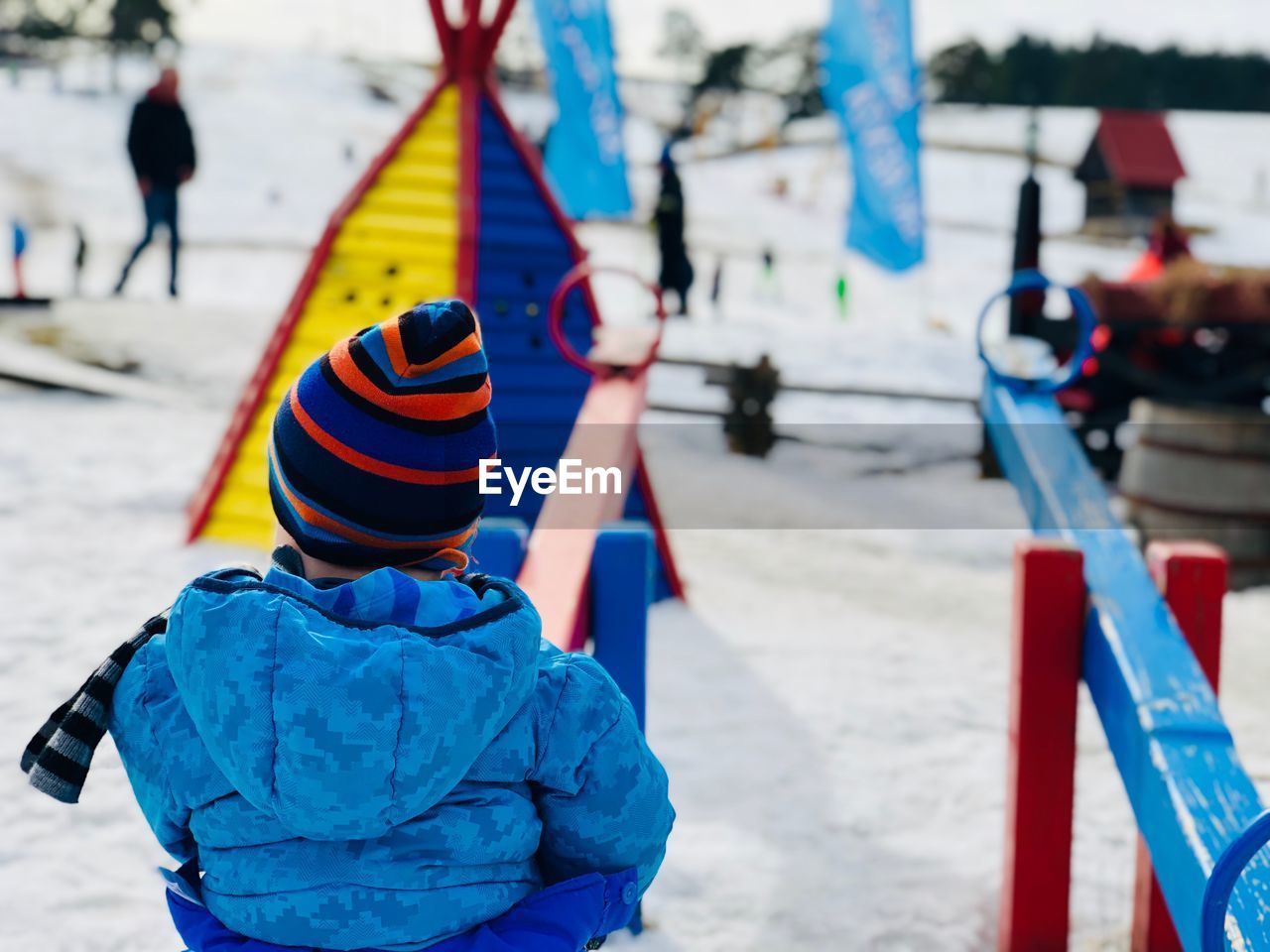 Rear view of boy playing on seesaw in playground