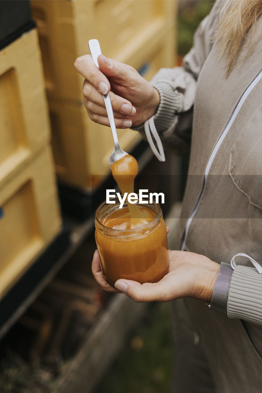 B beekeeper holding jar with honey