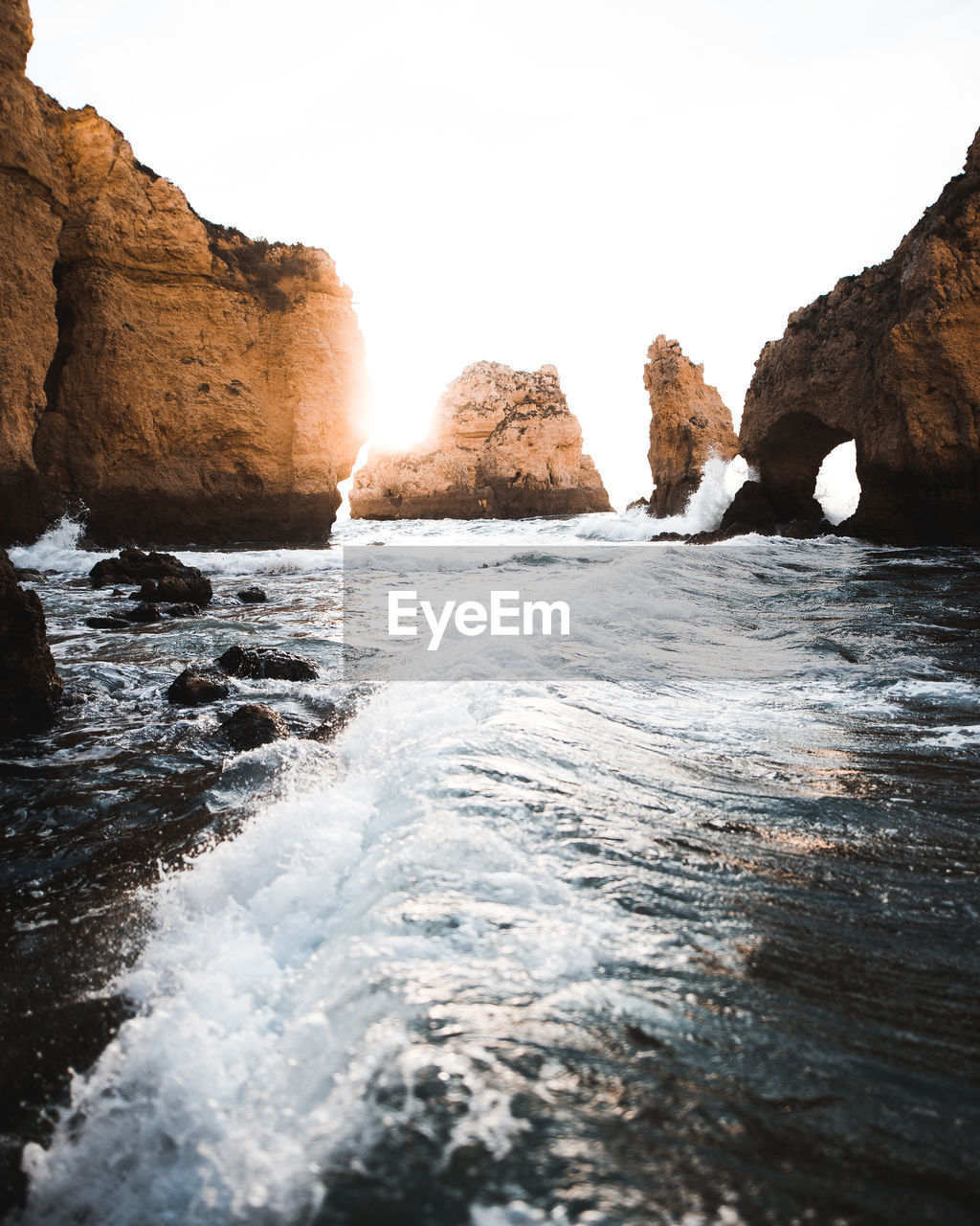 Scenic view of sea by rock formation against sky