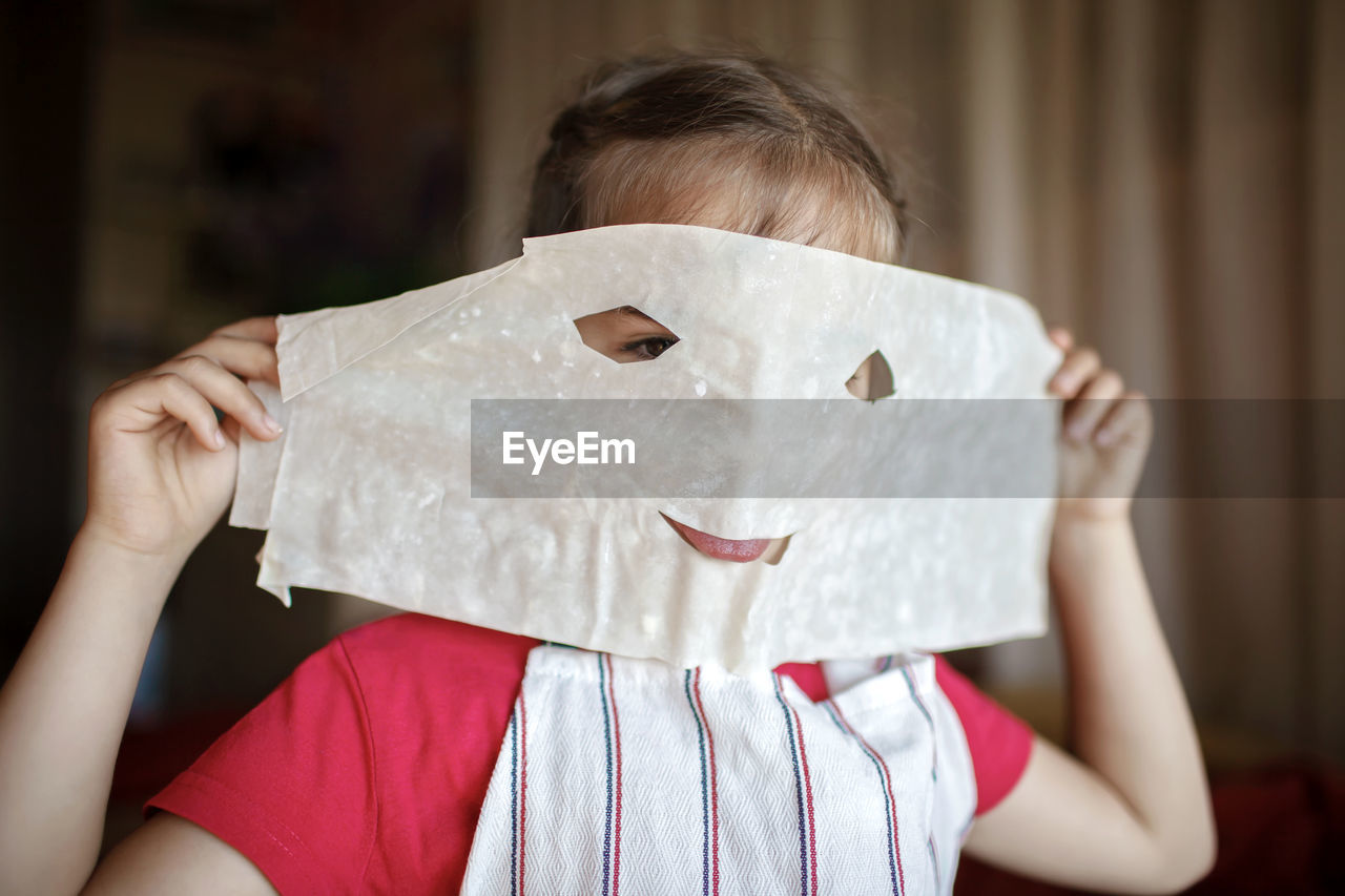 Girl covering face with wax paper