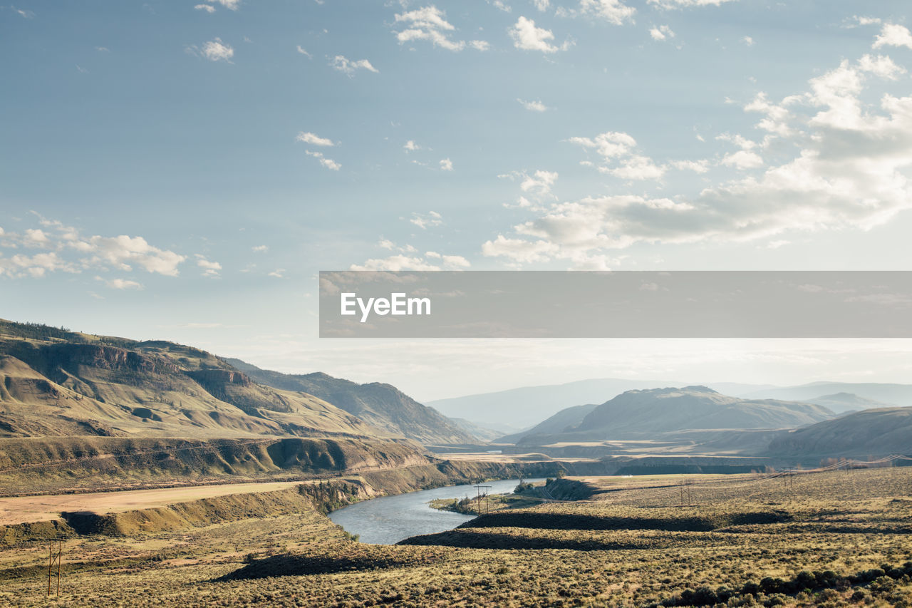 Scenic view of land and mountains against sky