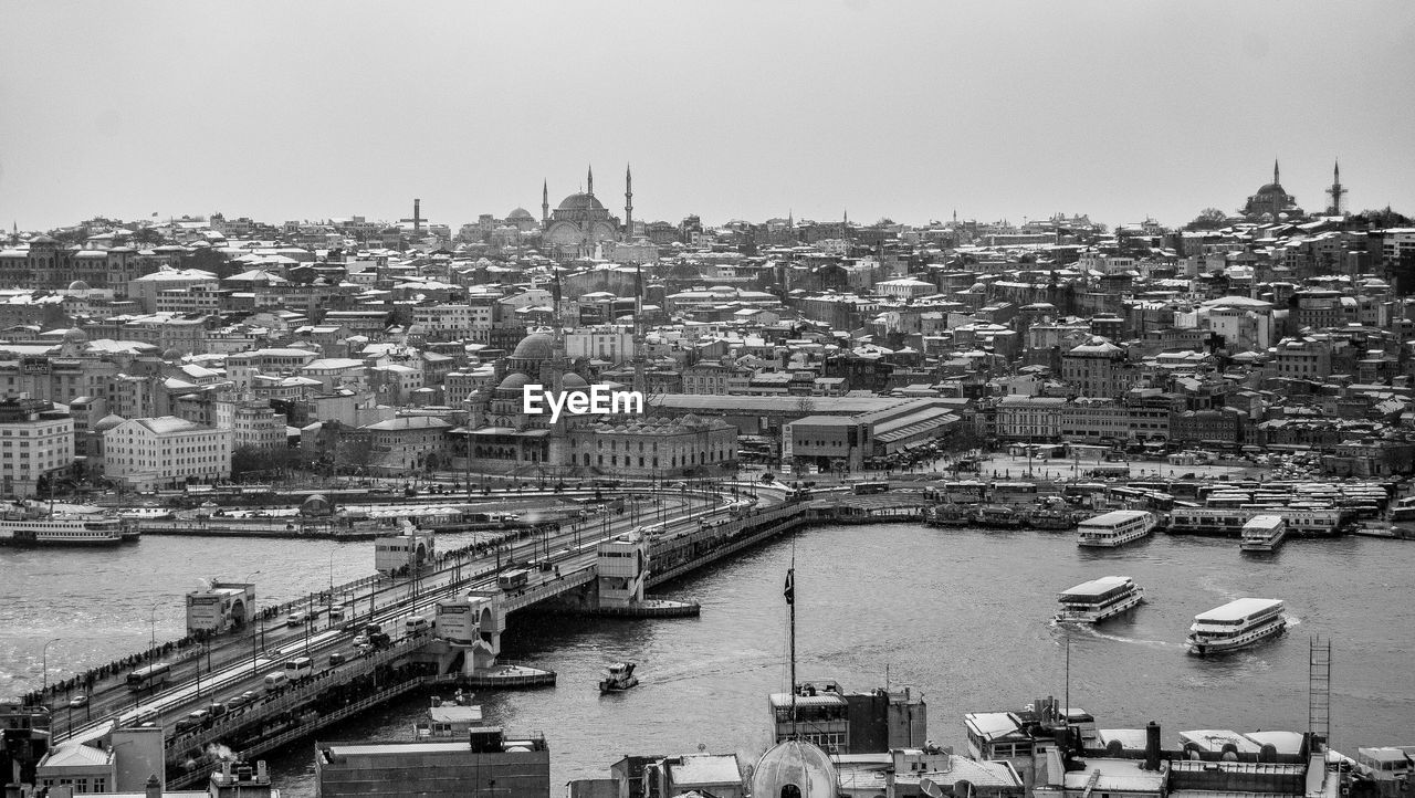 High angle view of boat moving on river against buildings in city