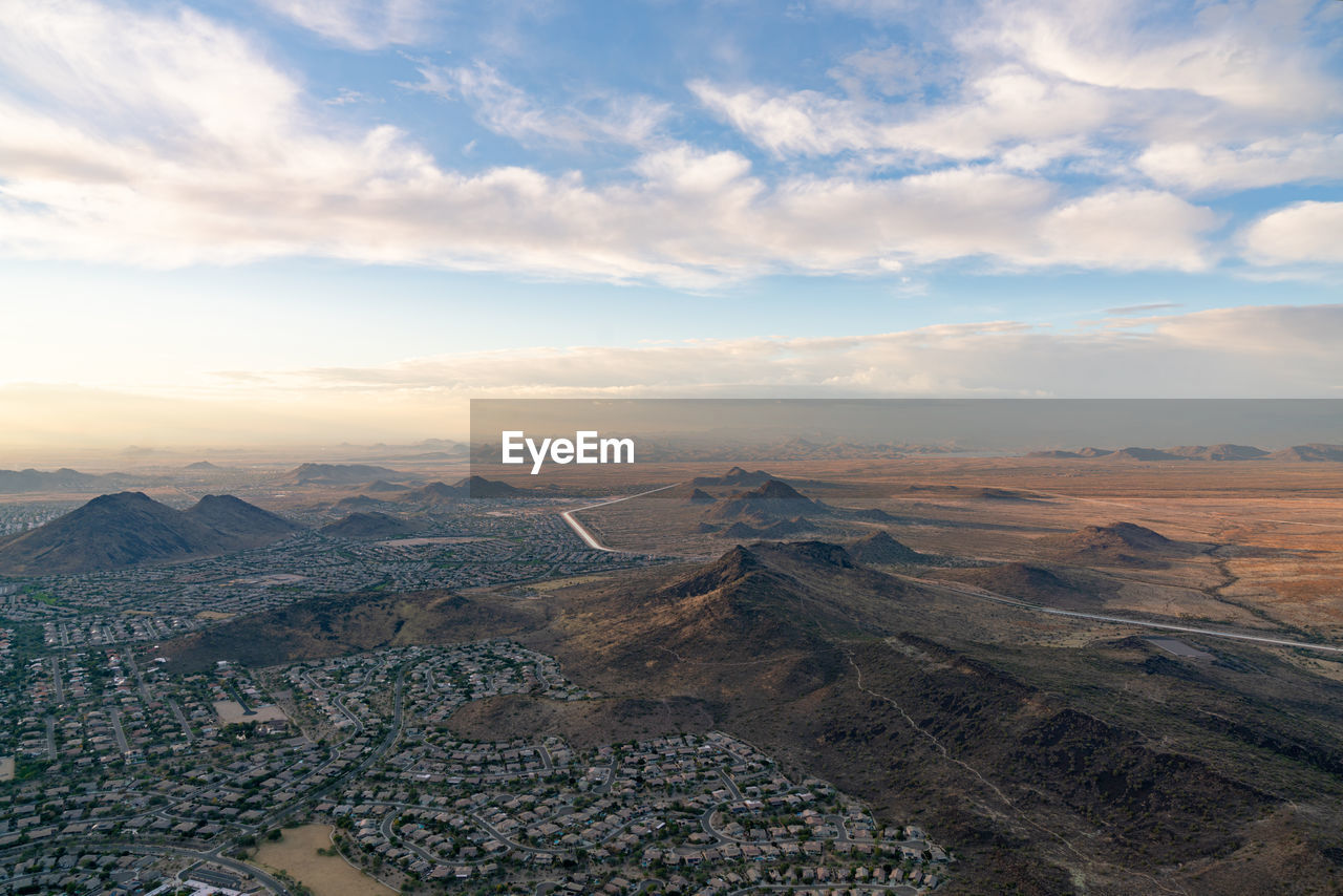 HIGH ANGLE VIEW OF CITY AGAINST CLOUDY SKY