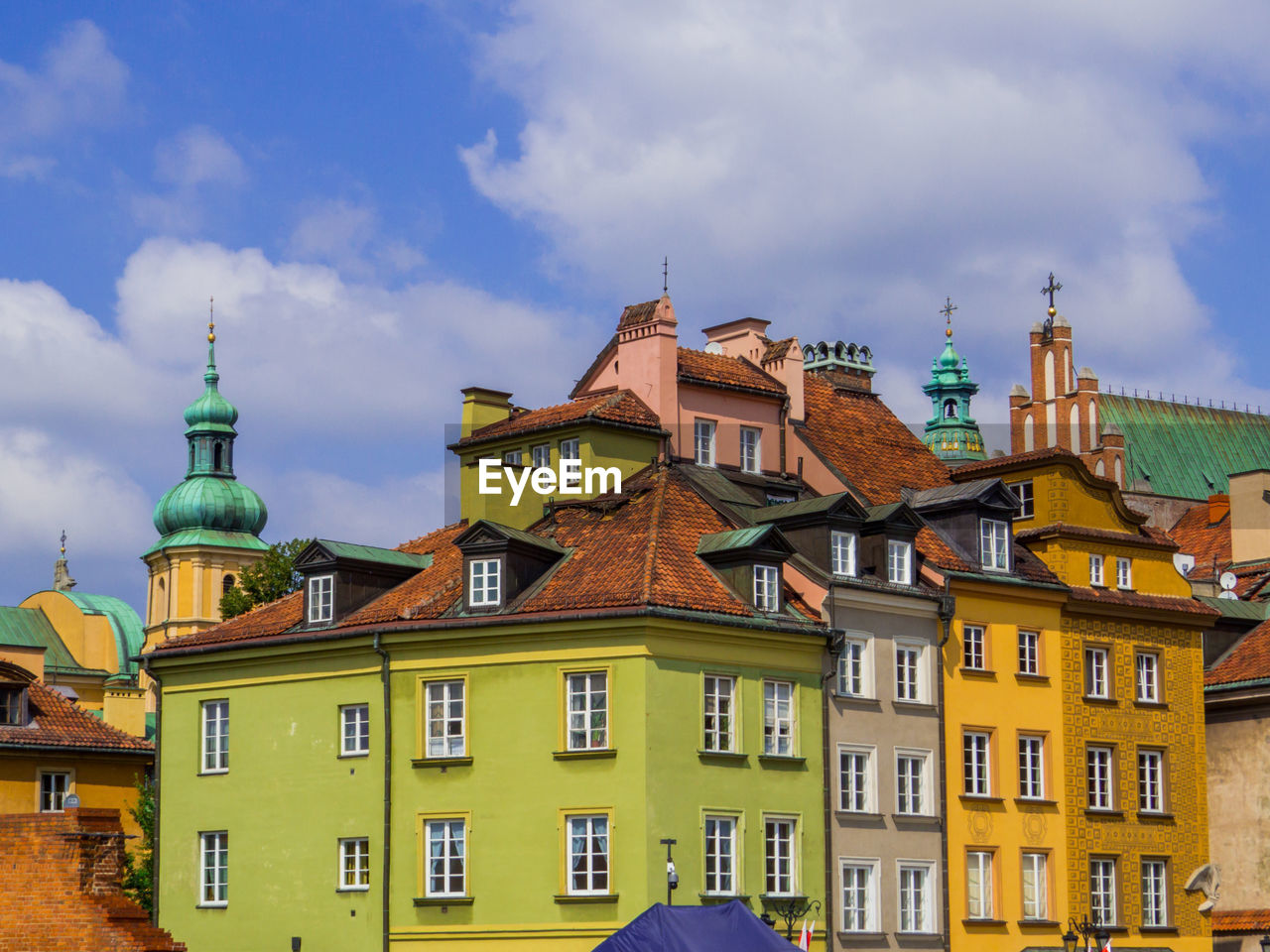 buildings in city against cloudy sky