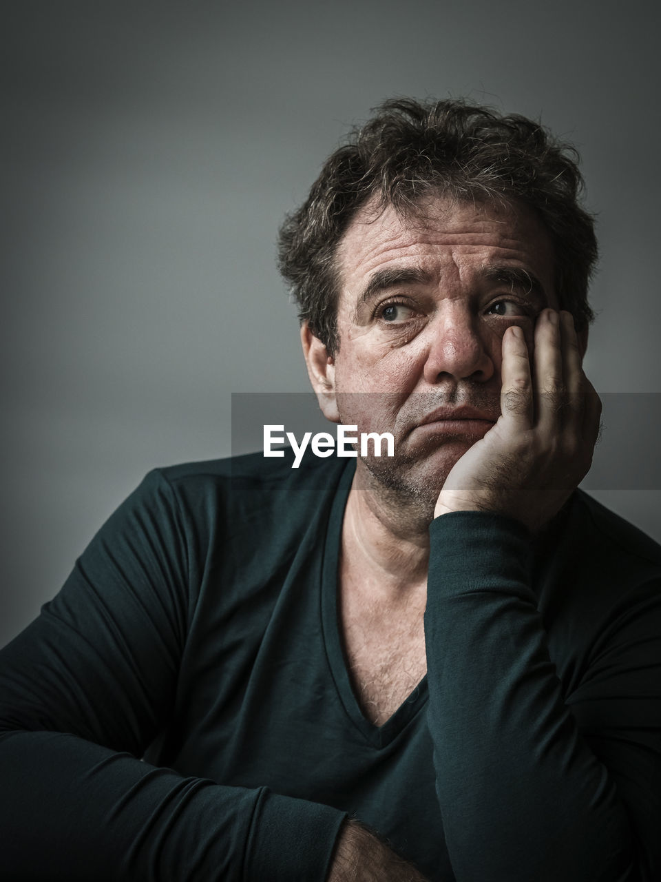 Depressed man looking away against gray background