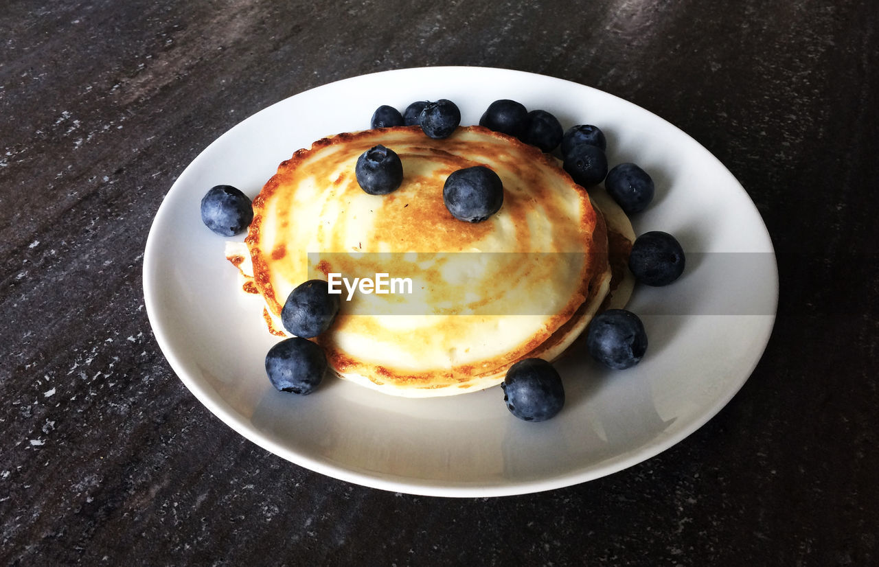 Close-up of pancakes with blueberries in plate on table