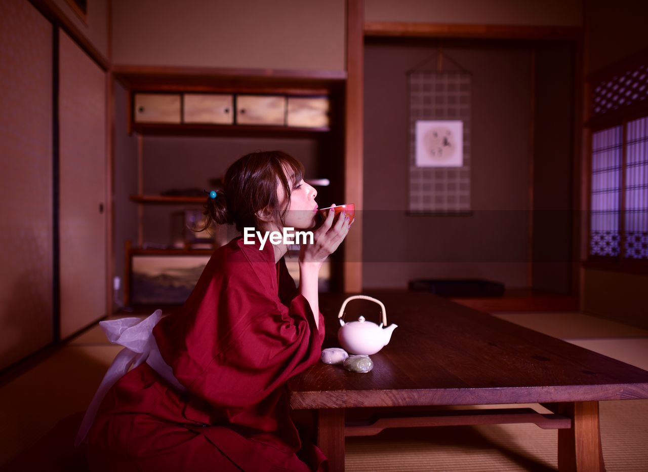 Woman drinking coffee cup on table at home