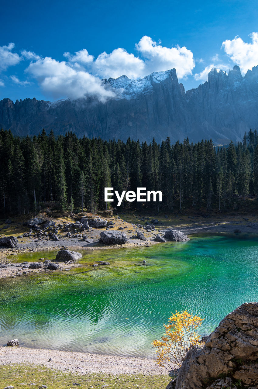 Scenic view of lake carezze  and mountains against sky in italy