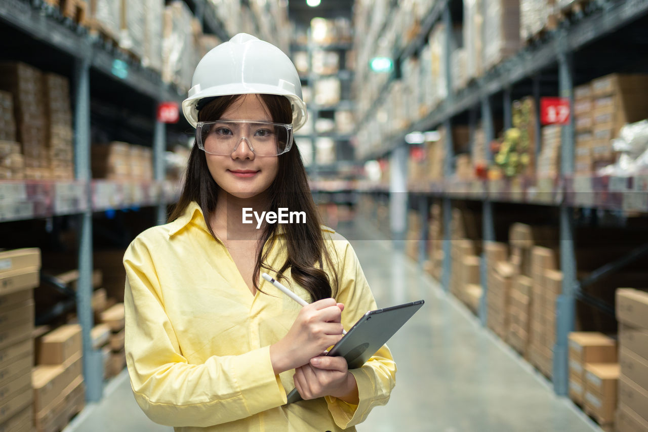 Female warehouse worker inspecting a warehouse in a factory. 