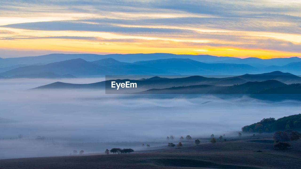 SCENIC VIEW OF LANDSCAPE AGAINST SUNSET SKY