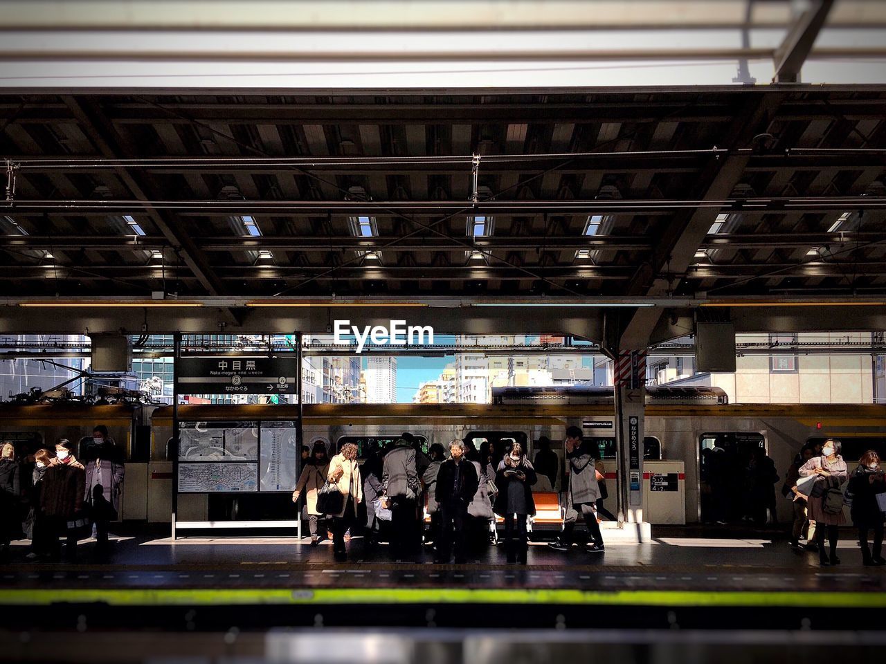 Commuters waiting at railroad station against train