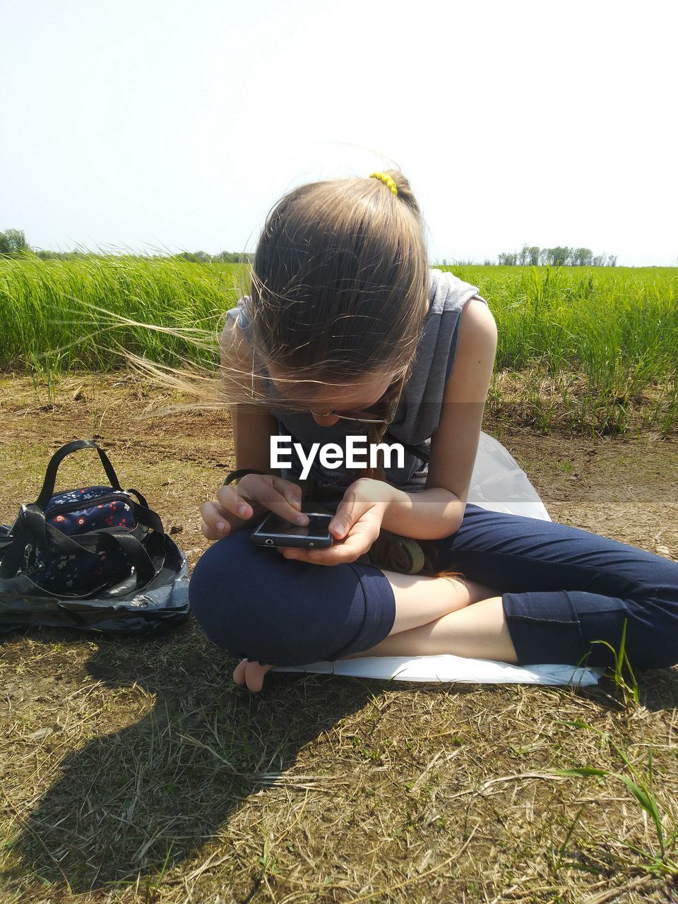 MIDSECTION OF WOMAN SITTING ON FIELD DURING RAINY SEASON