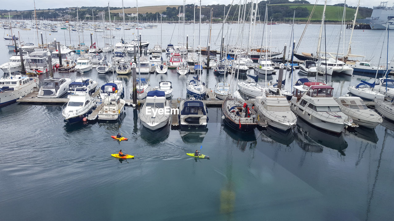 HIGH ANGLE VIEW OF BOATS MOORED AT SEA