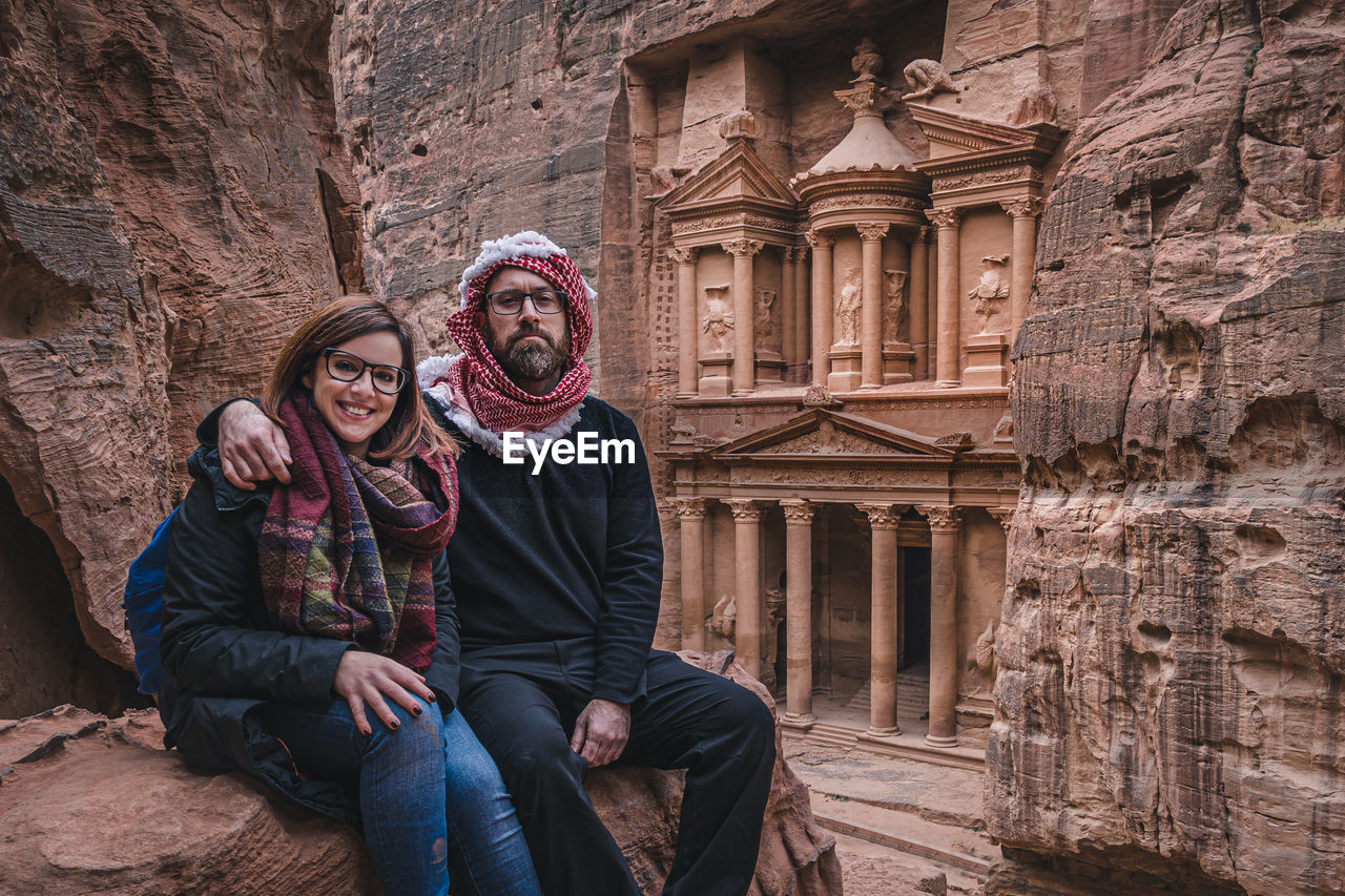 Portrait of couple sitting on rock formation