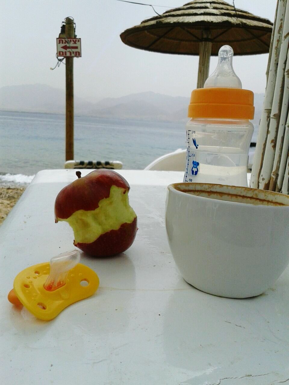 Close-up of coffee on table against calm sea