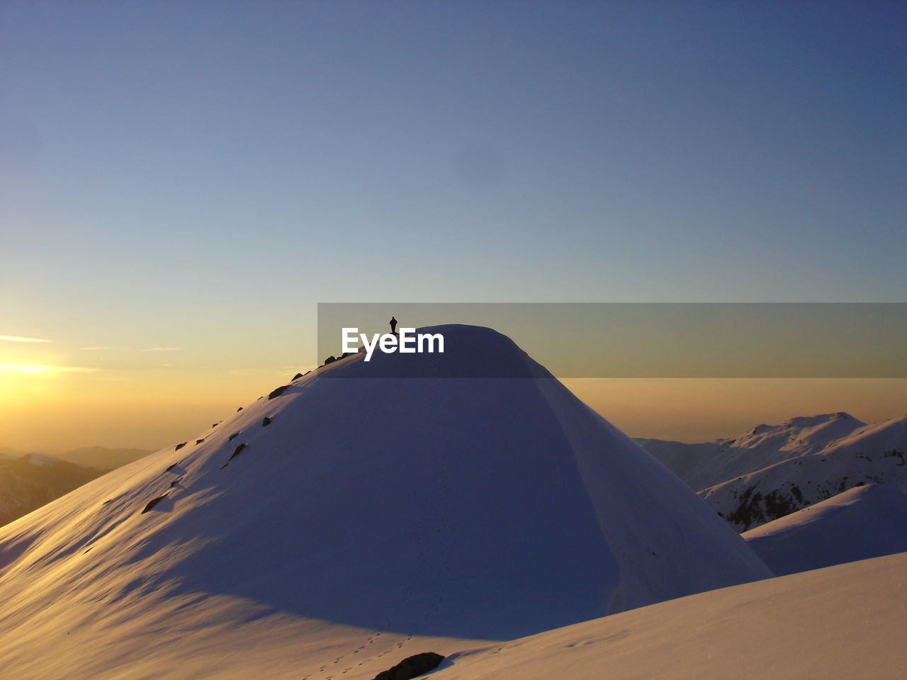 Scenic view of snowcapped mountains against sky during sunset