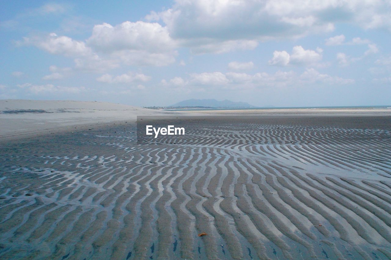 Surface level of sandy beach against sky