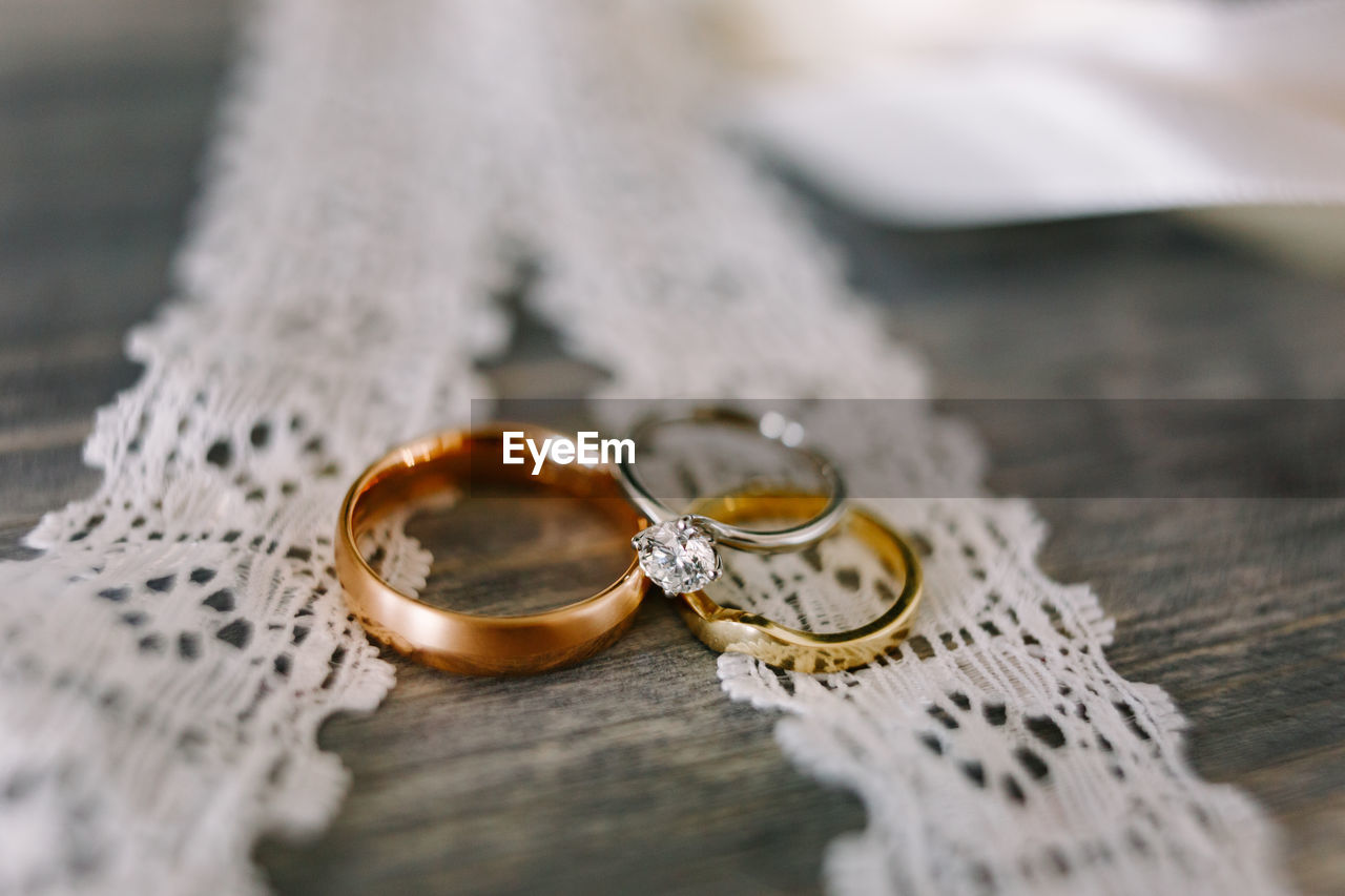HIGH ANGLE VIEW OF WEDDING RING ON TABLE