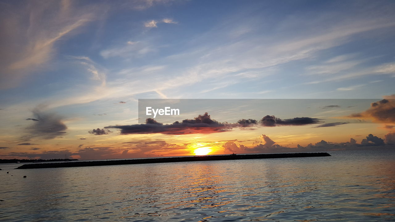 SCENIC VIEW OF SEA AGAINST ORANGE SKY