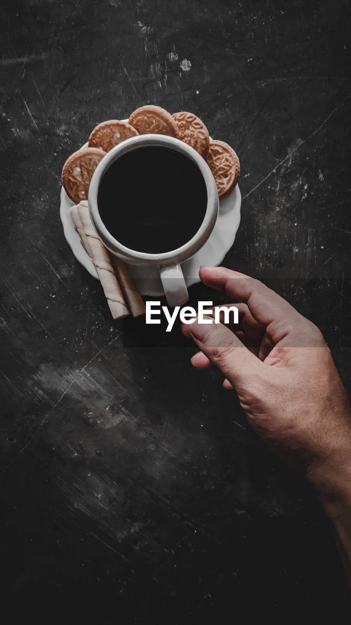 MIDSECTION OF COFFEE CUP ON TABLE WITH SPOON