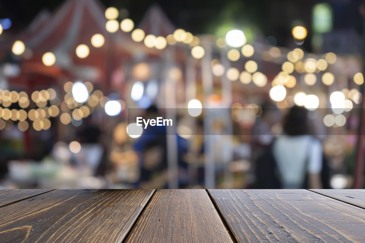 DEFOCUSED IMAGE OF ILLUMINATED LIGHTS AT RAILING