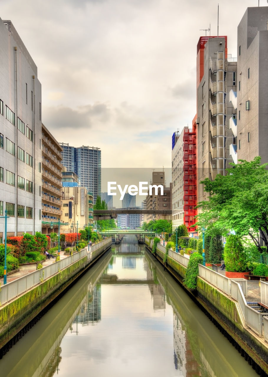 CANAL AMIDST BUILDINGS AGAINST SKY