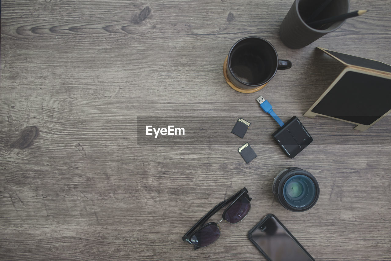 HIGH ANGLE VIEW OF COFFEE CUP ON WOODEN TABLE