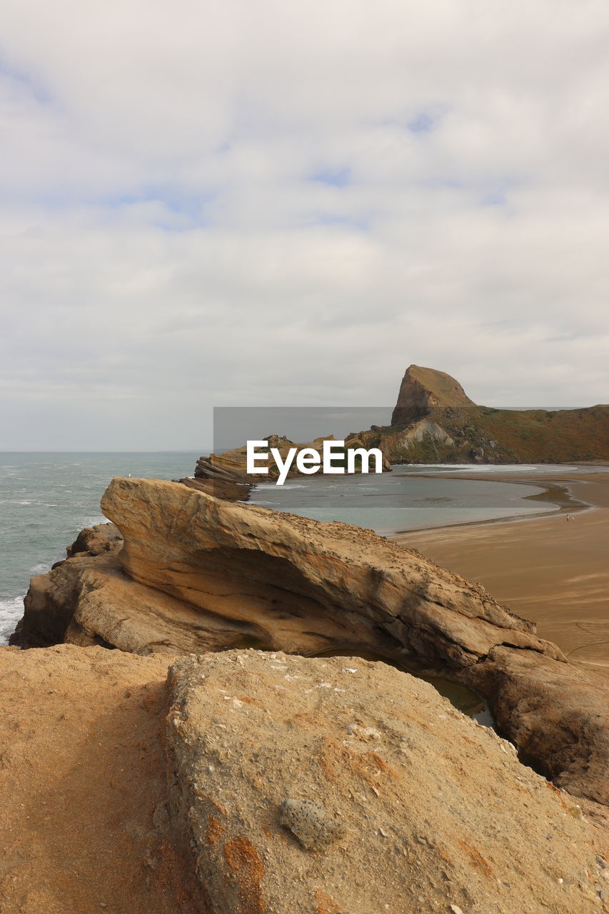 ROCKS ON SHORE AGAINST SKY