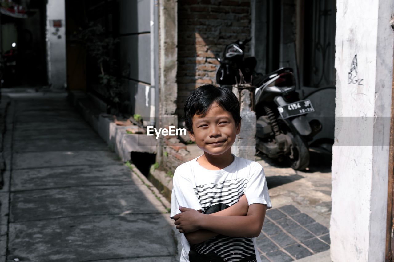 PORTRAIT OF CUTE BOY STANDING AT ENTRANCE