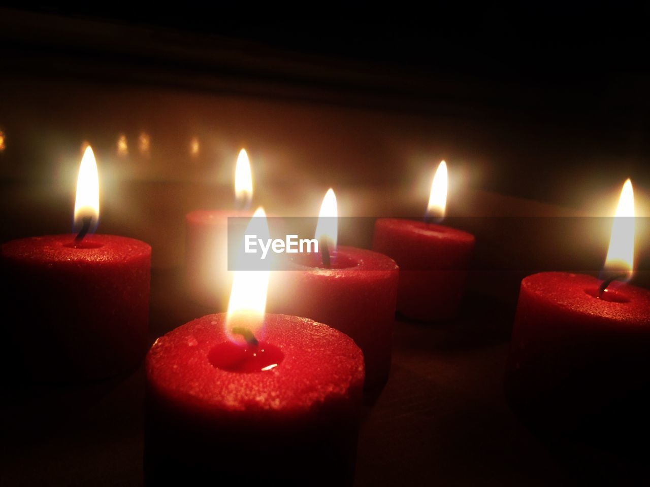 Close-up of red burning candles