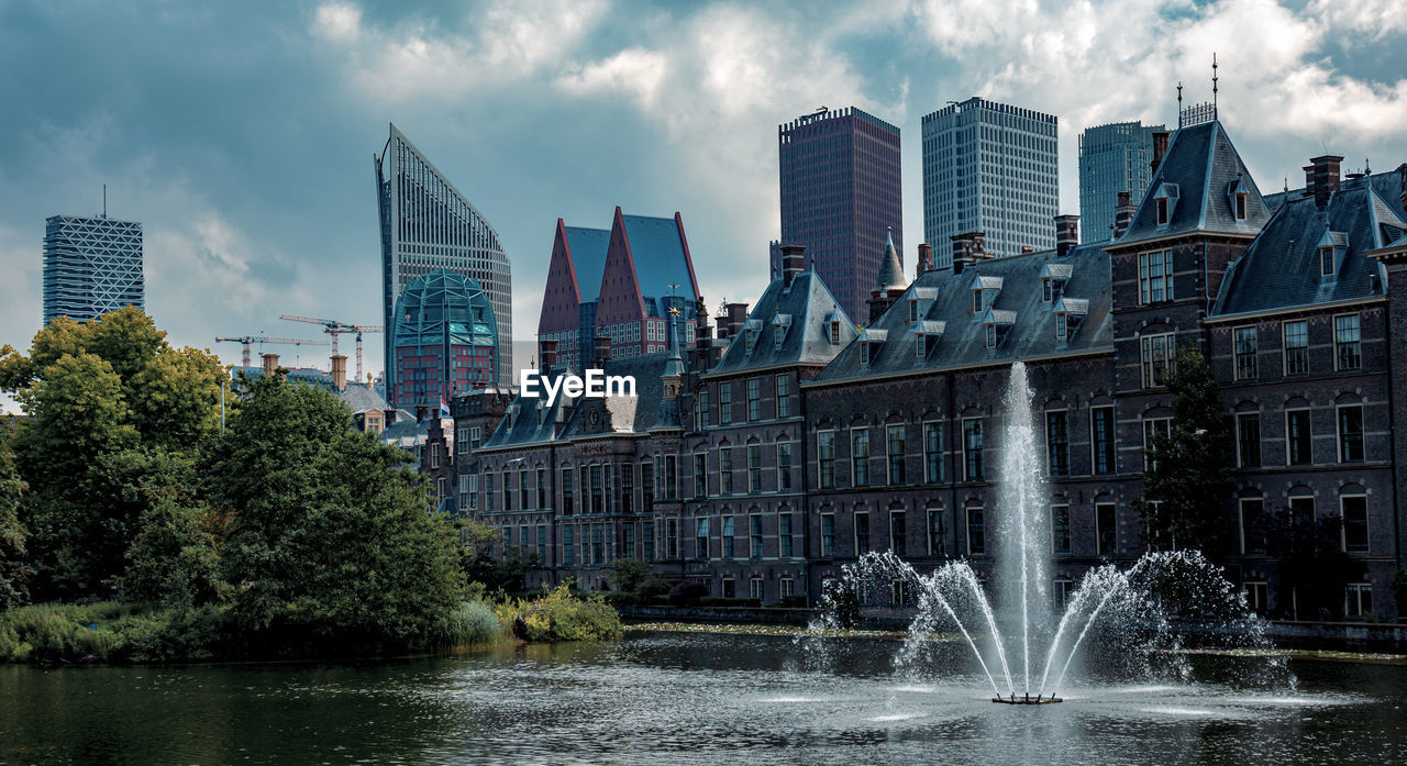 Fountain in city against sky