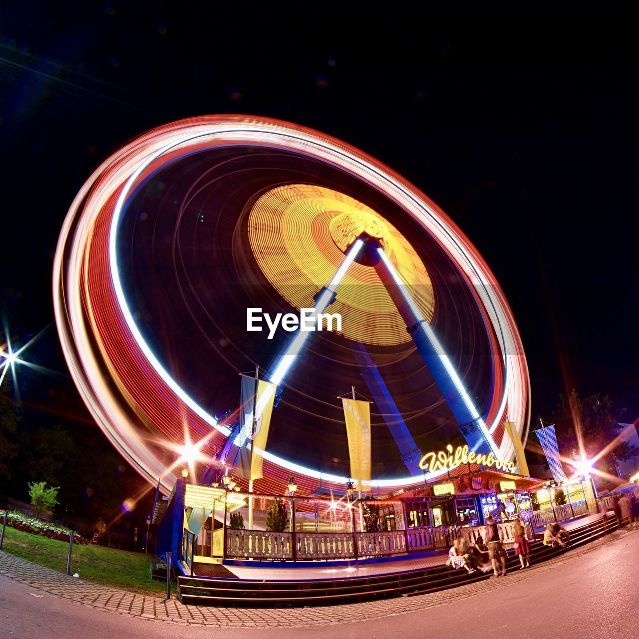 ILLUMINATED FERRIS WHEEL AGAINST SKY IN CITY AT NIGHT