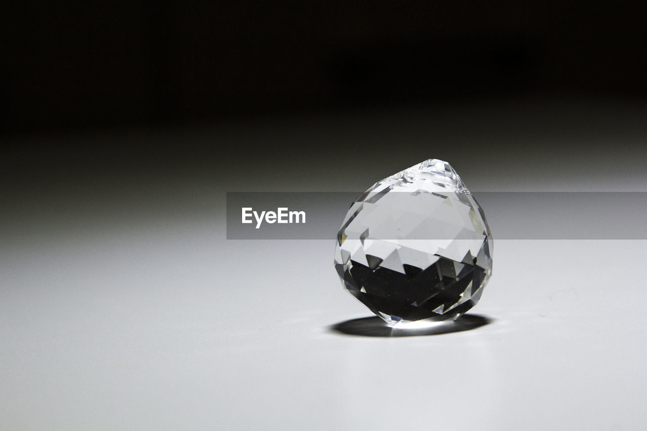 Close-up of crystal on table against black background