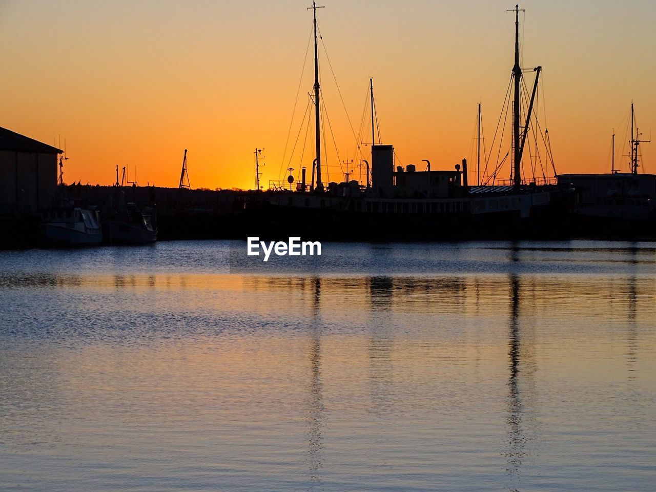 SILHOUETTE SAILBOATS IN MARINA AT SUNSET