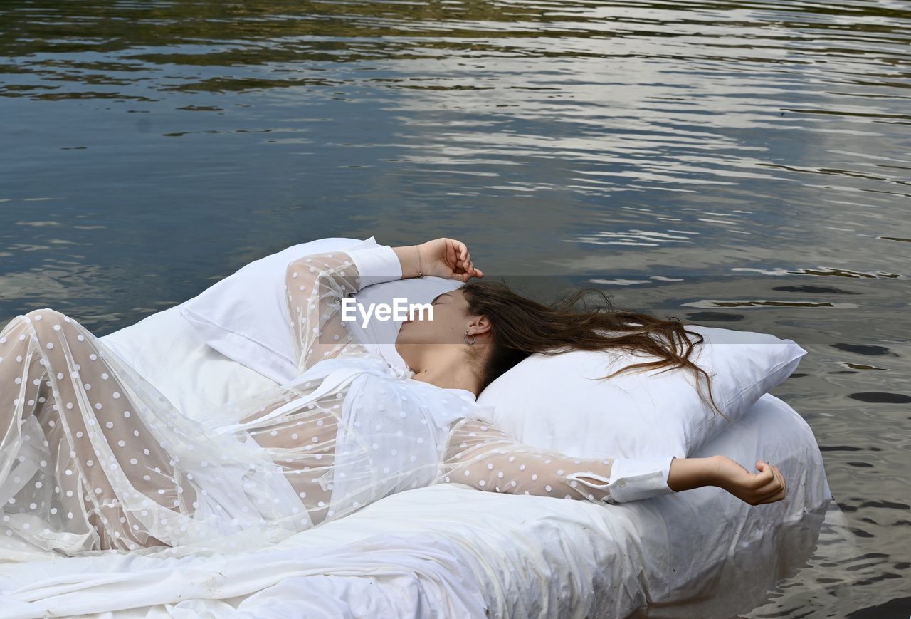 Young woman lying down in lake