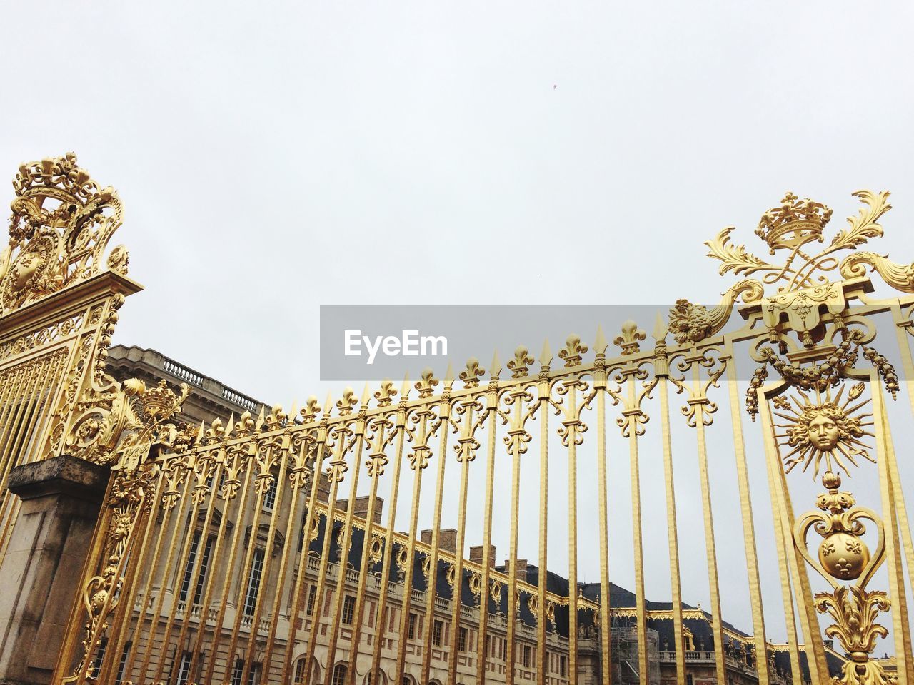 LOW ANGLE VIEW OF SCULPTURE AGAINST BUILDING AGAINST SKY