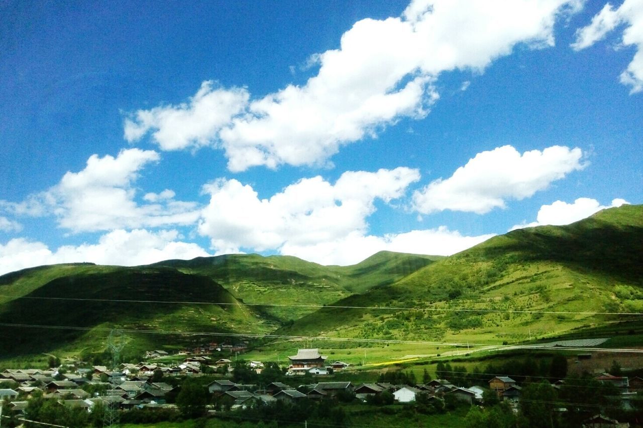 Scenic view of green mountains against sky