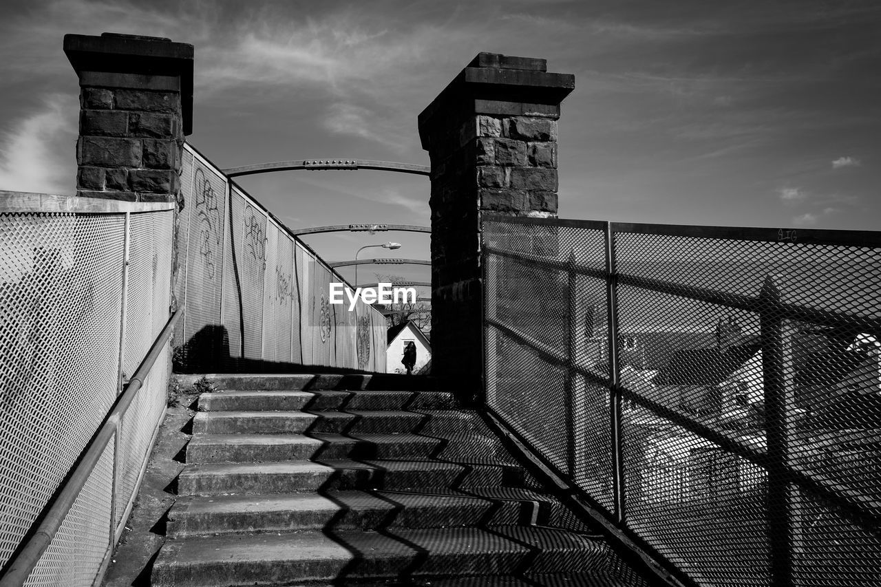 Low angle view of steps leading towards bridge in city