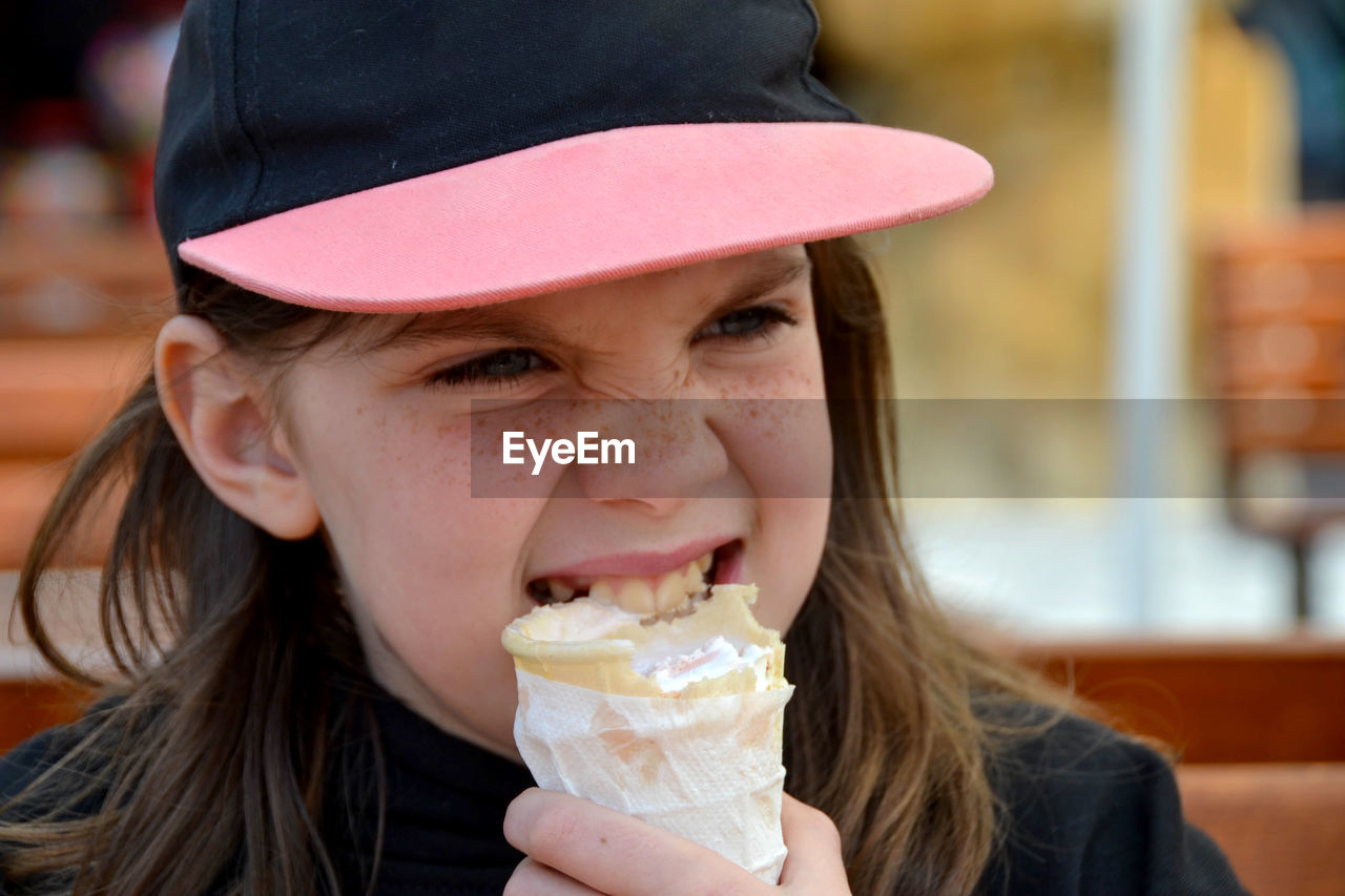 Close up image of girl hand holding fresh waffle cone with vanilla