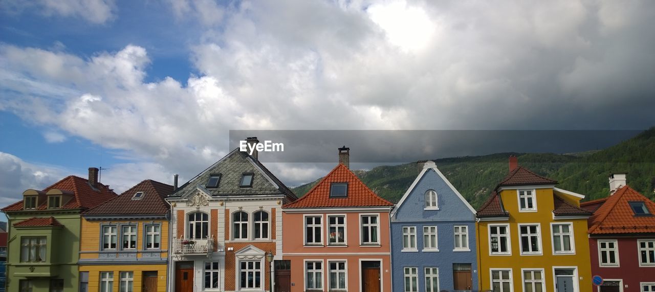 Panoramic view of buildings against cloudy sky